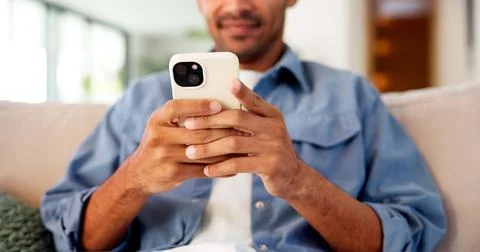 Phone, hands and man on sofa in home for texting, email or social media on Stock Photos