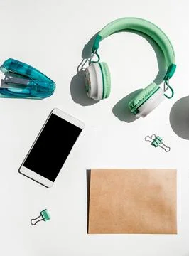 Phone, head phones, note and stationery isoalted over background, business or Stock Photos
