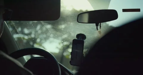 Phone holder on car dashboard with sunlight through windshield Stock Footage 326217892