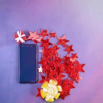 Phone in the left corner of the frame with red decorative stars, peeled 스톡 사진
