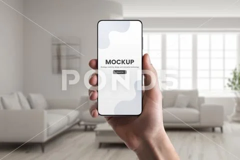 Phone mockup in hand with real estate interior in background PSD-Vorlage