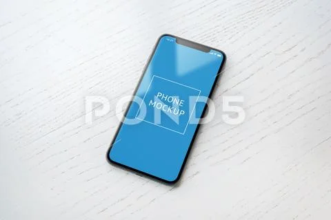 Phone mockup on whitee wooden table. Close-up scene with window light reflection PSD Template