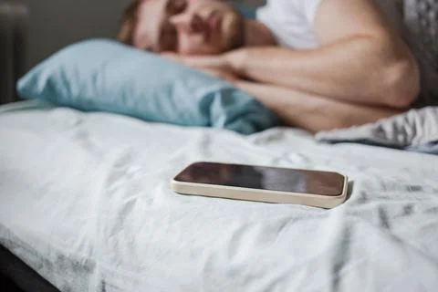 The phone next to the sleeping man Stock Photos