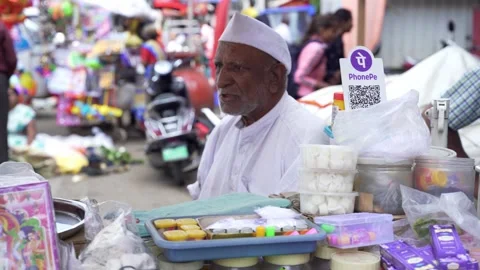 Phone Pe UPI QR code scanner at street side vendor selling incense sticks Stock Footage 304310151