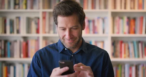 Phone, reading and scroll with man in library as college or university professor Video stock 336643855