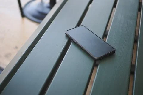 Phone resting on a table outdoors. lost smart phone concept Foto stock