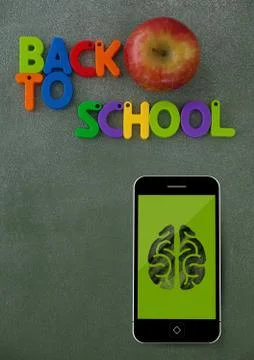 Phone on a school table with brain icon on screen Foto stock