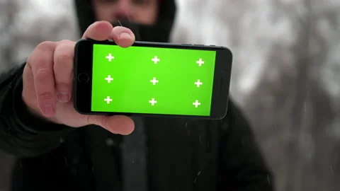 The phone screen is close-up in winter. A man holds a smartphone screen to the Stock Footage 168372133
