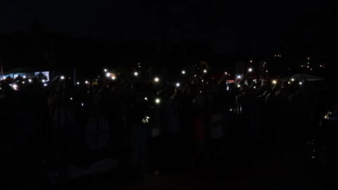 Phone screen light from a crowd by seaside, fa01 動画素材 277874474