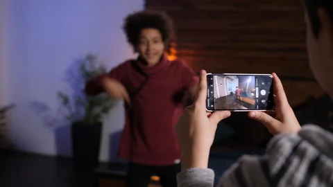 Phone shooting video of dancing mixed race boy Video stock 124933641