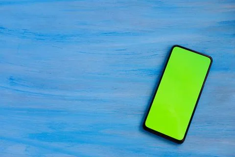 Phone smartphone, green screen on Blue wood background top view Stock Illustration