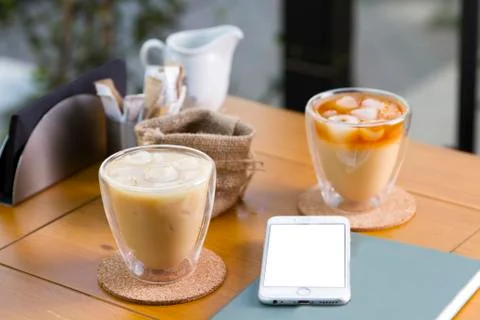 Phone is at the table white screen on above view with ice coffee Stock Photos
