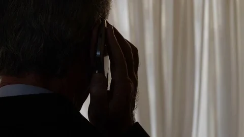 Phone tapping: A man speaks to the phone in shade Stock Footage 80911737
