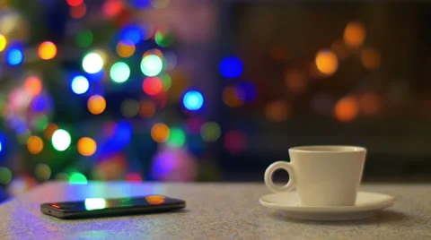 Phone touchscreen and cup of tea by flare, bokeh abstract varicolored background Stock-Footage 47163732