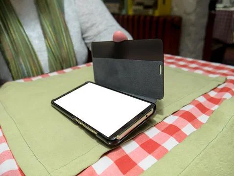 Phone with white screen template held by a woman in cafe Stock Photos