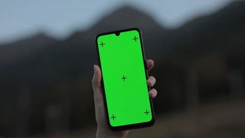 A phone in a woman's hands with a green screen and tracking points in the Stock Footage 148508030