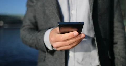 Phone - young businessman using smartphone in smart casual suit by office Stock Footage 112957391