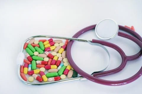 Phonendoscope, stethoscope, and bundle of tablets are scattered on an isolated Stock Photos