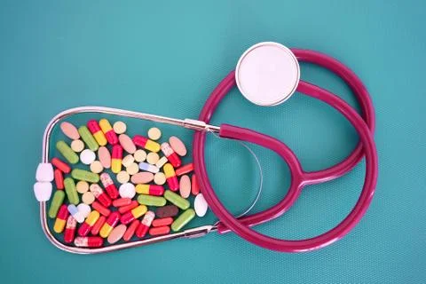 Phonendoscope, stethoscope, and bundle of tablets are scattered on an isolated Stock Photos