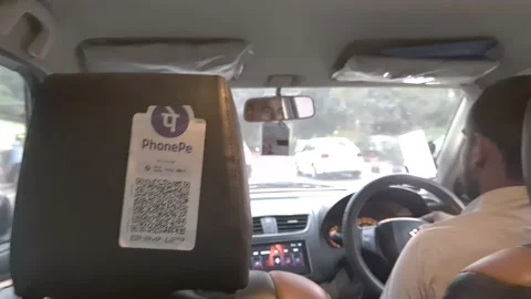 Phonepe QR code scanning card hung behind the tourist taxi seat Stock Footage 238794548