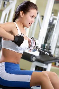 Photo of active girl pumping muscles on special equipment Stock Photos