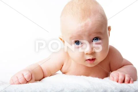 Photo of adorable infant crawling over fluffy rug Stock Photos