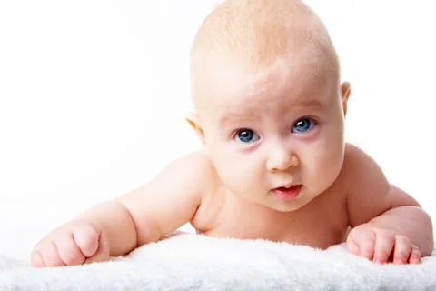 Photo of adorable infant crawling over fluffy rug Stock Photos