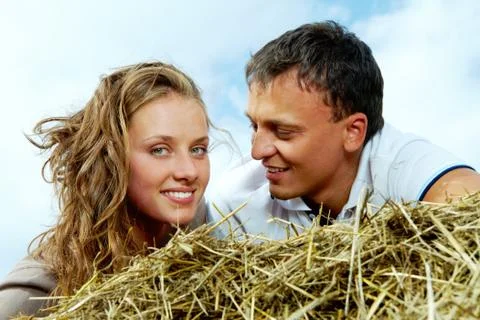 Photo of affectionate couple relaxing on haystack Stock Photos