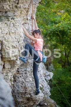 Photo of athlete girl clambering over rock Stock Photos