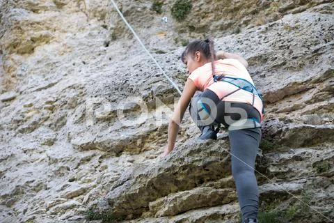 Photo of athlete girl clambering over rock Stock Photos