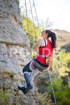 Photo of athlete girl clambering over rock Stock Photos