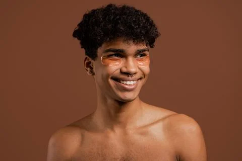 Photo of attractive black man with piercing with eye patches on smiles. Naked Stock Photos
