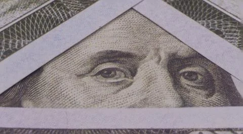 Photo of Benjamin Franklin's eyes in a triangular frame of 100 dollar bills Stock Photos