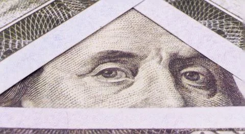 Photo of Benjamin Franklin's eyes in a triangular frame of 100 dollar bills Stock Photos
