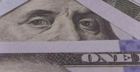 Photo of Benjamin Franklin's eyes in a triangular frame of 100 dollar bills Stock Photos
