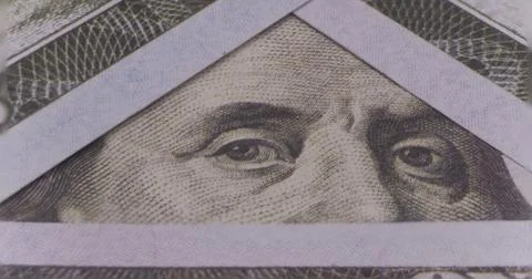 Photo of Benjamin Franklin's eyes in a triangular frame of 100 dollar bills Stock Photos