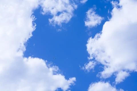Photo of bright cloudy sky with tiny birds flying high Stock Photos