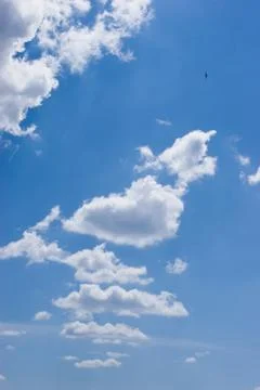 Photo of bright cloudy sky with tiny bird flying high Foto stock