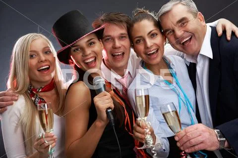 Photo of businesspeople with flutes of sparkling champagne singing christmas son Stock Photos
