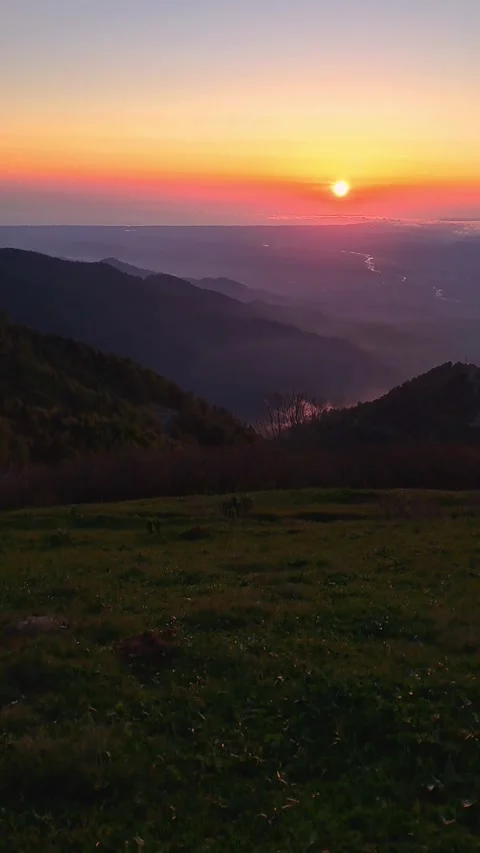 Photo camera on backpack looking at a scenic sunset over a misty mountain val Stock Footage 336707948