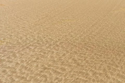 Photo capturing an abstract sand pattern created by the sea waves, showcasing Stock Photos