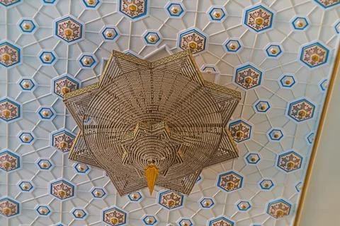 Photo of the ceiling with geometric patterns and a hanging chandelier of an.. Stock Photos