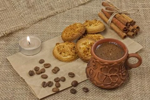 Photo of coffee cup, coffee beans, cinnamon, cookies and candle on craft pape Stock Photos