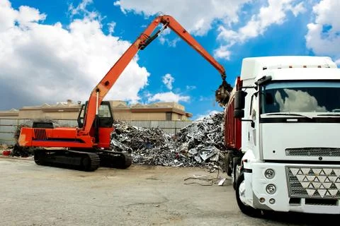 Photo of a crane loading a trailer under the sky with beautiful clouds Stock Photos