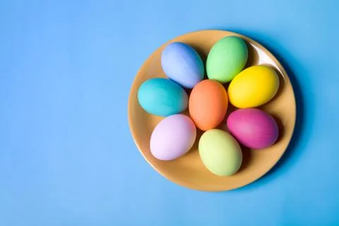 Photo of easter eggs lying on the saucer on a blue background Stock Photos