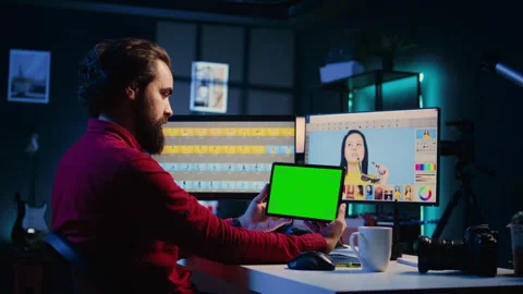 Photo editor following tutorial on green screen tablet, learning how to build Stock Footage 257495284