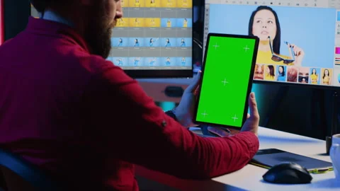 Photo editor learning from tutorial on green screen tablet while working in Stock Footage 257494746