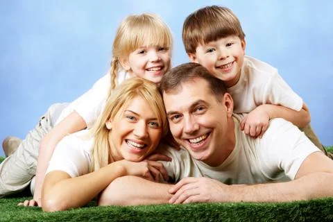 Photo of family members smiling at camera on blue background Stock Photos