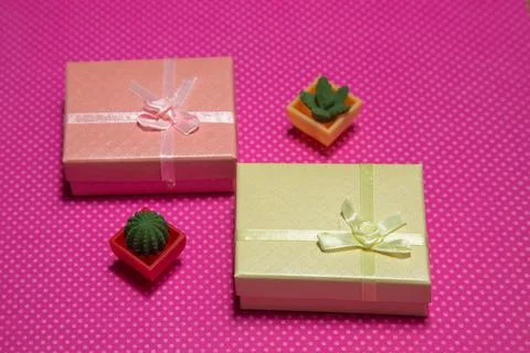 Photo flat lay of a gift boxes with a bow under points of view on a pink Stock Illustration