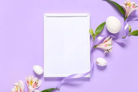 Photo frame with Easter eggs, alstroemeria flowers and ribbon on purple backg Stock Photos